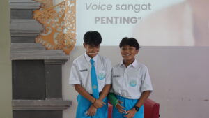 Siswa mempraktikkan cara smiling voice dengan menggigit stik es krim