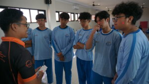 Potret siswa sedang mendengarkan instruksi dari trainer untuk disampaikan kepada kelompoknya