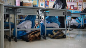 Momen ketika para siswa berlindung di bawah meja sebagai upaya penyelamatan diri