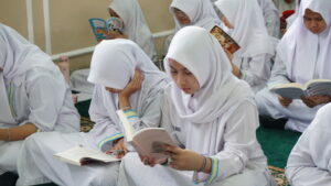 Seorang siswa terlihat tengah serius membaca novelnya