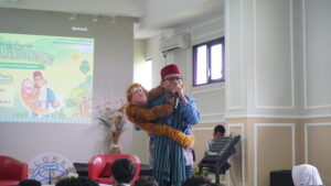 Potret Kak Awe tengah menggendong Yogi, boneka yang menjadi "teman"-nya dalam setiap dongeng