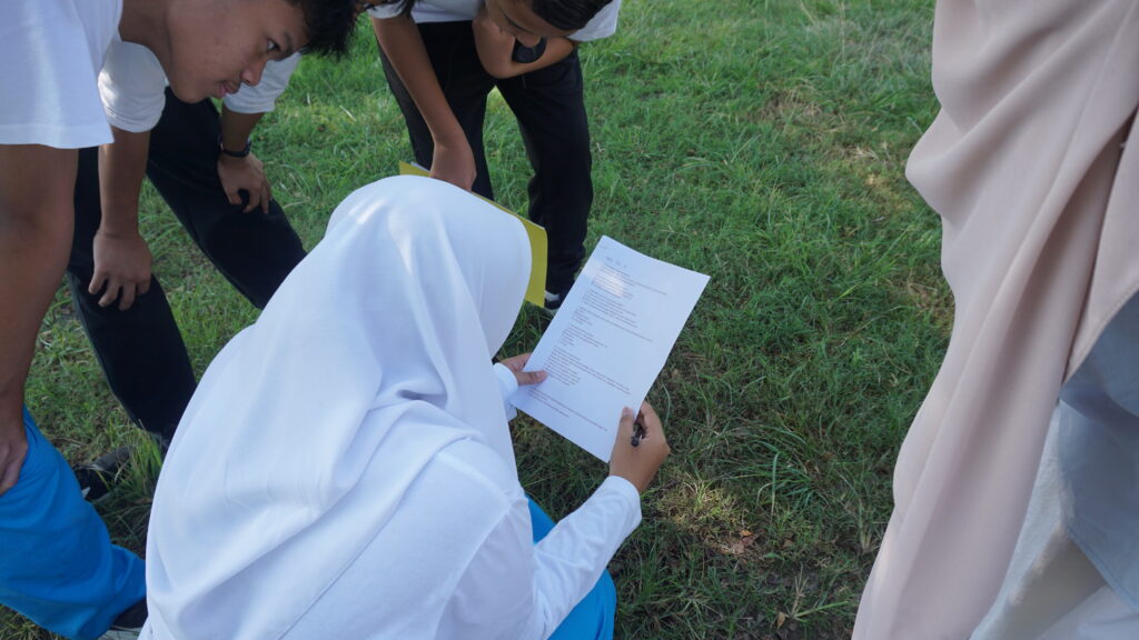 Salah satu kelompok siswa sedang bekerja sama menyelesaikan soal di pos 1