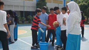 Satu kelompok siswa tampak sedang berdiskusi sebelum menjalankan game bola berantai