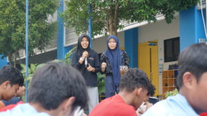 Dua anggota OSIS berdiri sambil meminta kritik dan saran dari para siswa