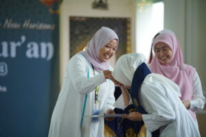 Momen ketika seorang siswa menerima selempang dan sertifikat wisuda Khatmul Qur'an
