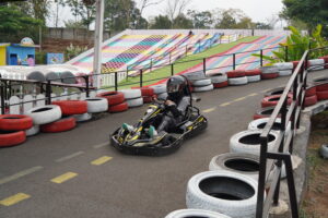 Momen seorang anak sedang bersenang-senang memacu lintasan di wahan go-kart