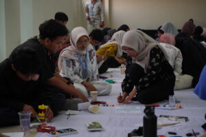 Ms. Ratih mengajarkan anak-anak cara menjiplak motif batik di atas pouch